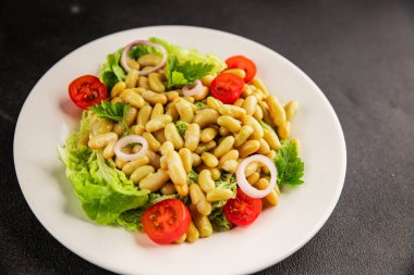 Fasulye salatası yeşil yaprak marul, domates, soğan tabağı taze lezzetli gurme yemek arkaplan masa üzerinde rustik gıda üst görünüm fotokopi alanı keto ve paleo diyet vegan ve vejetaryen gıda