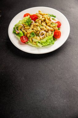 Fasulye salatası yeşil yaprak marul, domates, soğan tabağı taze lezzetli gurme yemek arkaplan masa üzerinde rustik gıda üst görünüm fotokopi alanı keto ve paleo diyet vegan ve vejetaryen gıda