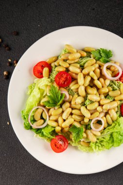 Fasulye salatası yeşil yaprak marul, domates, soğan tabağı taze lezzetli gurme yemek arkaplan masa üzerinde rustik gıda üst görünüm fotokopi alanı keto ve paleo diyet vegan ve vejetaryen gıda