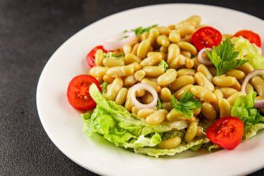 Fasulye salatası yeşil yaprak marul, domates, soğan tabağı taze lezzetli gurme yemek arkaplan masa üzerinde rustik gıda üst görünüm fotokopi alanı keto ve paleo diyet vegan ve vejetaryen gıda