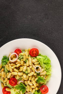 Fasulye salatası yeşil yaprak marul, domates, soğan tabağı taze lezzetli gurme yemek arkaplan masa üzerinde rustik gıda üst görünüm fotokopi alanı keto ve paleo diyet vegan ve vejetaryen gıda