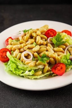 Fasulye salatası yeşil yaprak marul, domates, soğan tabağı taze lezzetli gurme yemek arkaplan masa üzerinde rustik gıda üst görünüm fotokopi alanı keto ve paleo diyet vegan ve vejetaryen gıda