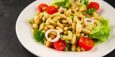 Fasulye salatası yeşil yaprak marul, domates, soğan tabağı taze lezzetli gurme yemek arkaplan masa üzerinde rustik gıda üst görünüm fotokopi alanı keto ve paleo diyet vegan ve vejetaryen gıda