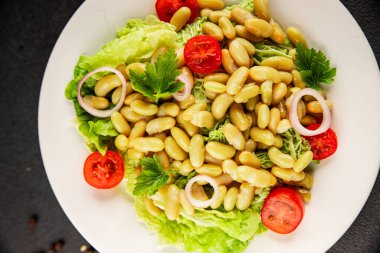 Fasulye salatası yeşil yaprak marul, domates, soğan tabağı taze lezzetli gurme yemek arkaplan masa üzerinde rustik gıda üst görünüm fotokopi alanı keto ve paleo diyet vegan ve vejetaryen gıda