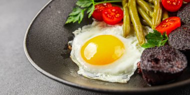 İngiliz kahvaltısı sahanda yumurta, kara puding, sebzeler, fasulye taze gurme yemek arkaplanı masanın kırsal kesiminde fotokopi alanı.
