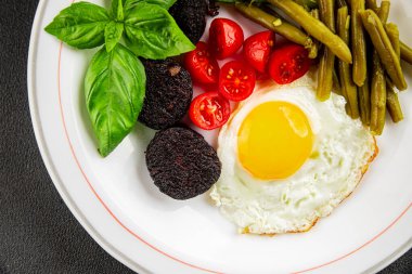 İngiliz kahvaltısı sahanda yumurta, kara puding, sebzeler, fasulye taze gurme yemek arkaplanı masanın kırsal kesiminde fotokopi alanı.