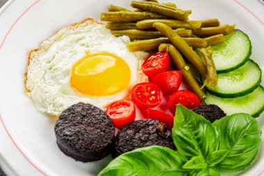 İngiliz kahvaltısı sahanda yumurta, kara puding, sebzeler, fasulye taze gurme yemek arkaplanı masanın kırsal kesiminde fotokopi alanı.