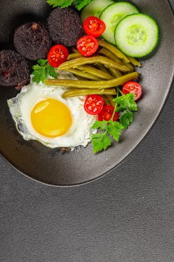 İngiliz kahvaltısı sahanda yumurta, kara puding, sebzeler, fasulye taze gurme yemek arkaplanı masanın kırsal kesiminde fotokopi alanı.
