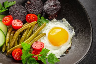 İngiliz kahvaltısı sahanda yumurta, kara puding, sebzeler, fasulye taze gurme yemek arkaplanı masanın kırsal kesiminde fotokopi alanı.
