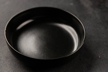 Tabak siyah sofra takımı boş yemek takımı tabakları servis etmeye hazır sofra arkasında yemek seramik tabağı servis etmeye hazır.