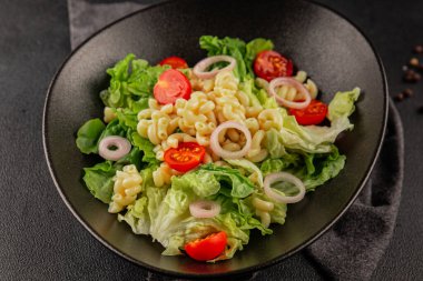 Makarna salatası yeşil yaprak marul, domates, makarna, soğan taze lezzetli gurme yemek arkaplan masa üzerinde rustik gıda üst görünüm fotokopi alanı keto ve paleo diyet vegan ve vejetaryen gıda