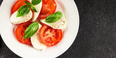 Caprese salatası mozzarella ve domates, fesleğen taze lezzetli gurme yemek arkaplan masa üzerinde rustik gıda üst görünüm fotokopi alanı keto ve paleo diyet vegan ve vegan gıda