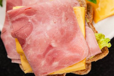 Sandviç, peynir, ekmek tostu, konserve jambon masadaki lezzetli gurme yemek arkaplanı kırsal yemek üst görünüm fotokopi alanı.