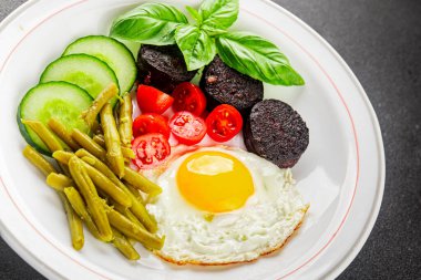 İngiliz kahvaltısı sahanda yumurta, kara puding, sebzeler, fasulye taze gurme yemek arkaplanı masanın kırsal kesiminde fotokopi alanı.