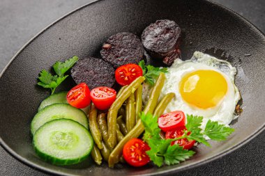 İngiliz kahvaltısı sahanda yumurta, kara puding, sebzeler, fasulye taze gurme yemek arkaplanı masanın kırsal kesiminde fotokopi alanı.