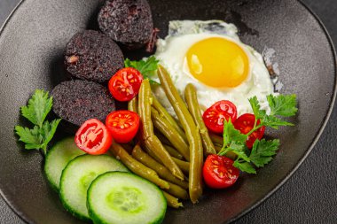 İngiliz kahvaltısı sahanda yumurta, kara puding, sebzeler, fasulye taze gurme yemek arkaplanı masanın kırsal kesiminde fotokopi alanı.