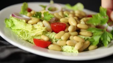 Fasulye salatası yeşil yaprak marul, domates, soğan tabağı taze lezzetli gurme yemek arkaplan masa üzerinde rustik gıda üst görünüm fotokopi alanı keto ve paleo diyet vegan ve vejetaryen gıda