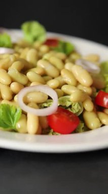 Fasulye salatası yeşil yaprak marul, domates, soğan tabağı taze lezzetli gurme yemek arkaplan masa üzerinde rustik gıda üst görünüm fotokopi alanı keto ve paleo diyet vegan ve vejetaryen gıda