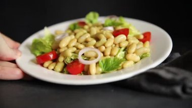 Fasulye salatası yeşil yaprak marul, domates, soğan tabağı taze lezzetli gurme yemek arkaplan masa üzerinde rustik gıda üst görünüm fotokopi alanı keto ve paleo diyet vegan ve vejetaryen gıda