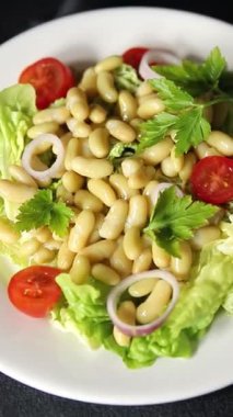 Fasulye salatası yeşil yaprak marul, domates, soğan tabağı taze lezzetli gurme yemek arkaplan masa üzerinde rustik gıda üst görünüm fotokopi alanı keto ve paleo diyet vegan ve vejetaryen gıda