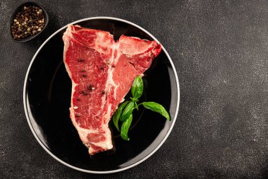 Çiğ biftek T-bone taze et prim biftek aperatif taze lezzetli gurme yemek arka planı masa rustik gıda üst görünüm fotokopi alanı