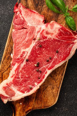 Çiğ biftek T-bone taze et prim biftek aperatif taze lezzetli gurme yemek arka planı masa rustik gıda üst görünüm fotokopi alanı