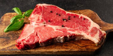 Çiğ biftek T-bone taze et prim biftek aperatif taze lezzetli gurme yemek arka planı masa rustik gıda üst görünüm fotokopi alanı