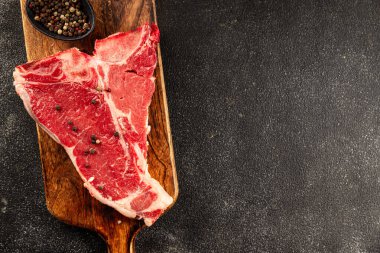 Çiğ biftek T-bone taze et prim biftek aperatif taze lezzetli gurme yemek arka planı masa rustik gıda üst görünüm fotokopi alanı