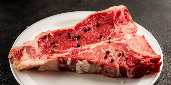 Çiğ biftek T-bone taze et prim biftek aperatif taze lezzetli gurme yemek arka planı masa rustik gıda üst görünüm fotokopi alanı