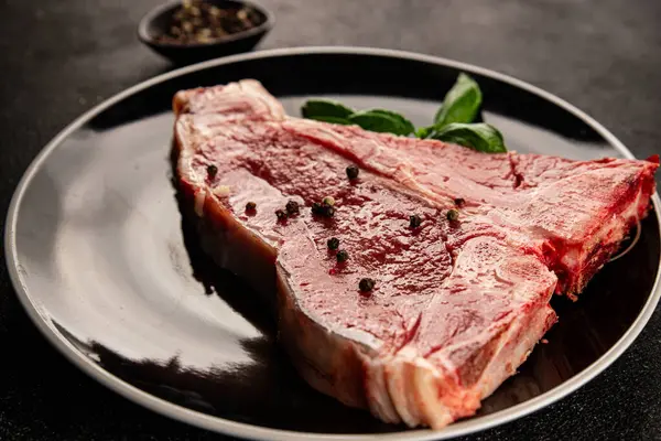 Çiğ biftek T-bone taze et prim biftek aperatif taze lezzetli gurme yemek arka planı masa rustik gıda üst görünüm fotokopi alanı