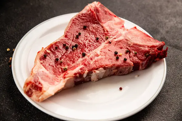Çiğ biftek T-bone taze et prim biftek aperatif taze lezzetli gurme yemek arka planı masa rustik gıda üst görünüm fotokopi alanı