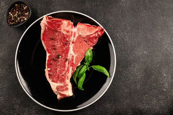 Çiğ biftek T-bone taze et prim biftek aperatif taze lezzetli gurme yemek arka planı masa rustik gıda üst görünüm fotokopi alanı