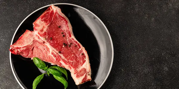 Çiğ biftek T-bone taze et prim biftek aperatif taze lezzetli gurme yemek arka planı masa rustik gıda üst görünüm fotokopi alanı
