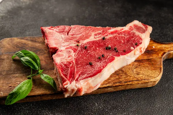 Çiğ biftek T-bone taze et prim biftek aperatif taze lezzetli gurme yemek arka planı masa rustik gıda üst görünüm fotokopi alanı