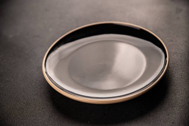 Tabak siyah sofra takımı boş yemek takımı tabakları servis etmeye hazır sofra arkasında yemek seramik tabağı servis etmeye hazır.