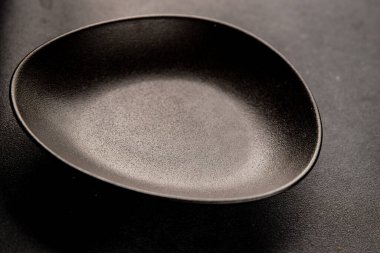 Tabak siyah sofra takımı boş yemek takımı tabakları servis etmeye hazır sofra arkasında yemek seramik tabağı servis etmeye hazır.