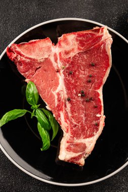 Çiğ biftek T-bone taze et prim biftek aperatif taze lezzetli gurme yemek arka planı masa rustik gıda üst görünüm fotokopi alanı