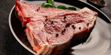 Çiğ biftek T-bone taze et prim biftek aperatif taze lezzetli gurme yemek arka planı masa rustik gıda üst görünüm fotokopi alanı