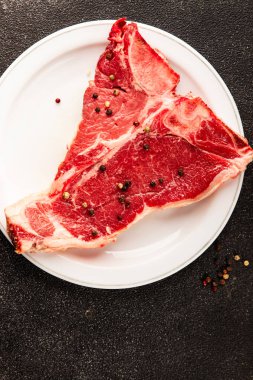 Çiğ biftek T-bone taze et prim biftek aperatif taze lezzetli gurme yemek arka planı masa rustik gıda üst görünüm fotokopi alanı