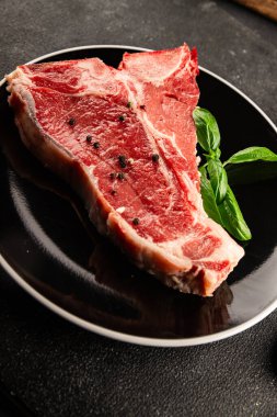 Çiğ biftek T-bone taze et prim biftek aperatif taze lezzetli gurme yemek arka planı masa rustik gıda üst görünüm fotokopi alanı