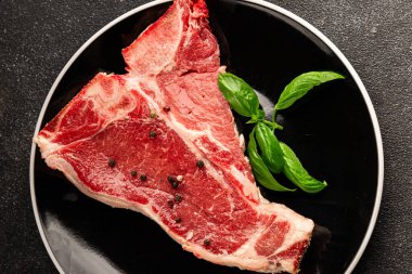 Çiğ biftek T-bone taze et prim biftek aperatif taze lezzetli gurme yemek arka planı masa rustik gıda üst görünüm fotokopi alanı