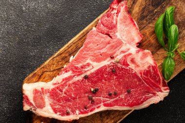 Çiğ biftek T-bone taze et prim biftek aperatif taze lezzetli gurme yemek arka planı masa rustik gıda üst görünüm fotokopi alanı