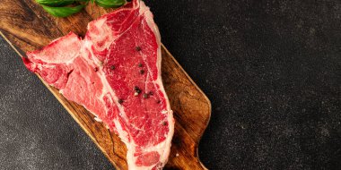Çiğ biftek T-bone taze et prim biftek aperatif taze lezzetli gurme yemek arka planı masa rustik gıda üst görünüm fotokopi alanı