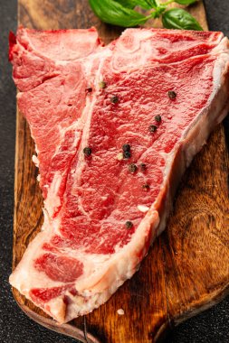 Çiğ biftek T-bone taze et prim biftek aperatif taze lezzetli gurme yemek arka planı masa rustik gıda üst görünüm fotokopi alanı