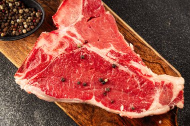 Çiğ biftek T-bone taze et prim biftek aperatif taze lezzetli gurme yemek arka planı masa rustik gıda üst görünüm fotokopi alanı