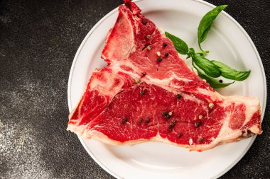 Çiğ biftek T-bone taze et prim biftek aperatif taze lezzetli gurme yemek arka planı masa rustik gıda üst görünüm fotokopi alanı