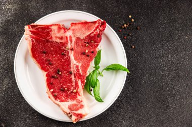 Çiğ biftek T-bone taze et prim biftek aperatif taze lezzetli gurme yemek arka planı masa rustik gıda üst görünüm fotokopi alanı