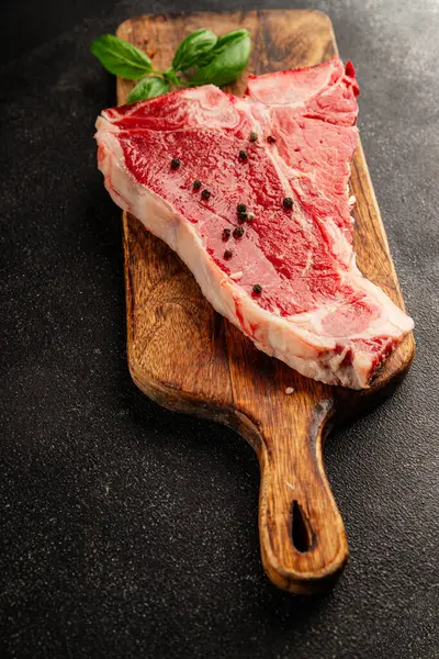 Çiğ biftek T-bone taze et prim biftek aperatif taze lezzetli gurme yemek arka planı masa rustik gıda üst görünüm fotokopi alanı