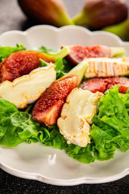 Salata inciri, yumuşak peynir, yeşil yaprak marul lezzetli aperatif lezzetli lezzetli gurme yemek arkaplan masa üzerinde rustik gıda üst görünüm fotokopi alanı keto ve paleo diyet vejetaryen gıda