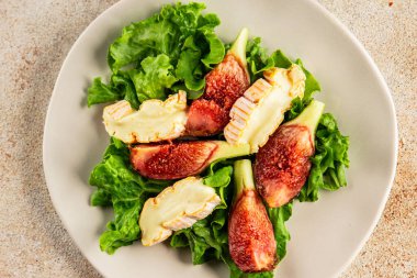 Salata inciri, yumuşak peynir, yeşil yaprak marul lezzetli aperatif lezzetli lezzetli gurme yemek arkaplan masa üzerinde rustik gıda üst görünüm fotokopi alanı keto ve paleo diyet vejetaryen gıda